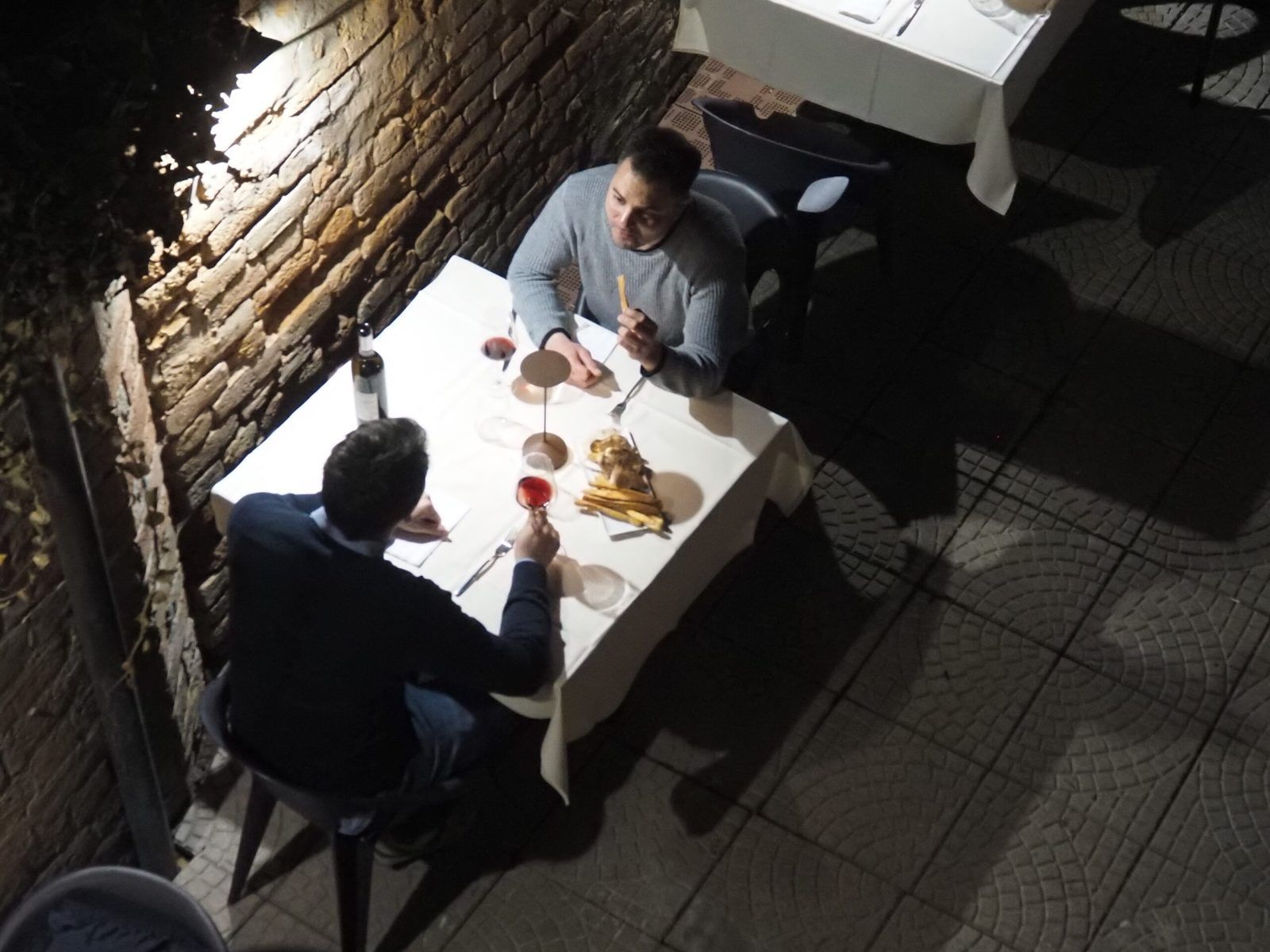 Ospiti a tavola nella sala in mattoni dell'Osteria SUTA